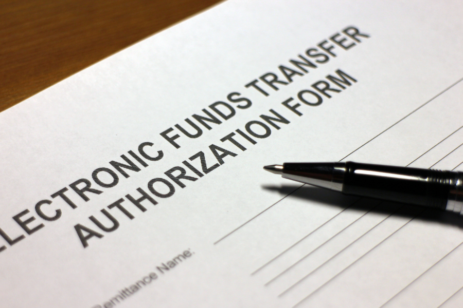 Pen resting on top of an electronic funds transfer form