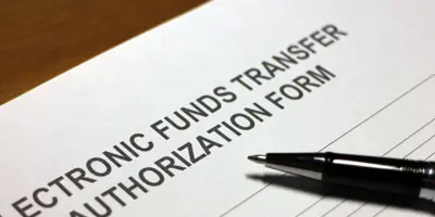 Pen resting on top of an electronic funds transfer form