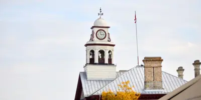 Side view of the clocktower on Perth Town Hall with a tree with yellow leaves in the foreground